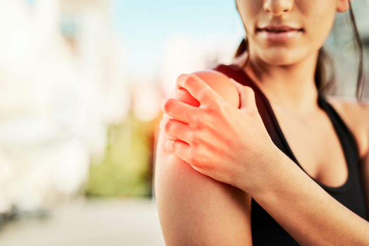 Woman holding her shoulder experiencing pain